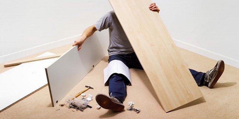 A man struggles to assemble flat-packed furniture